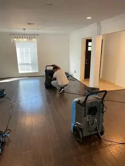 Technician setting up a dehumidifier during a water damage dry-out