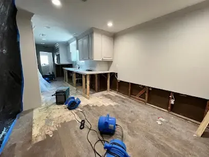 Flood cut along a kitchen wall with air movers drying the opening