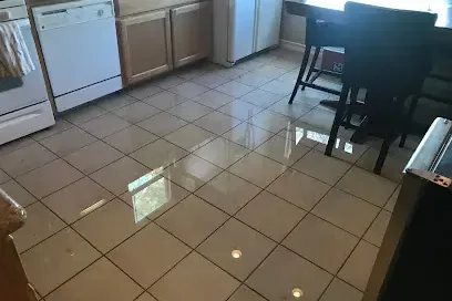 Water spread across kitchen tile from a leaking dishwasher