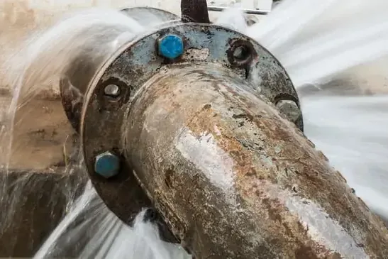 Water spraying from a failed pipe joint