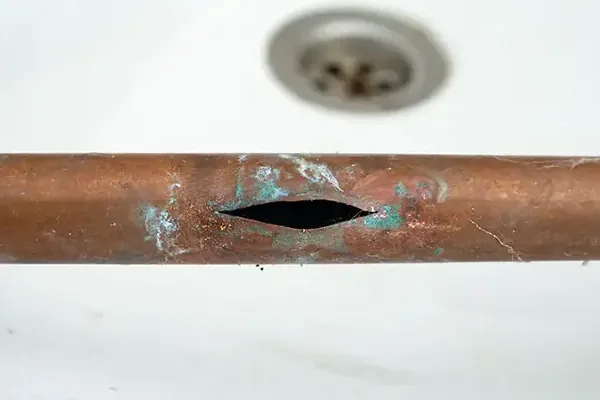 Copper water pipe with a pinhole leak, the kind found under a concrete slab