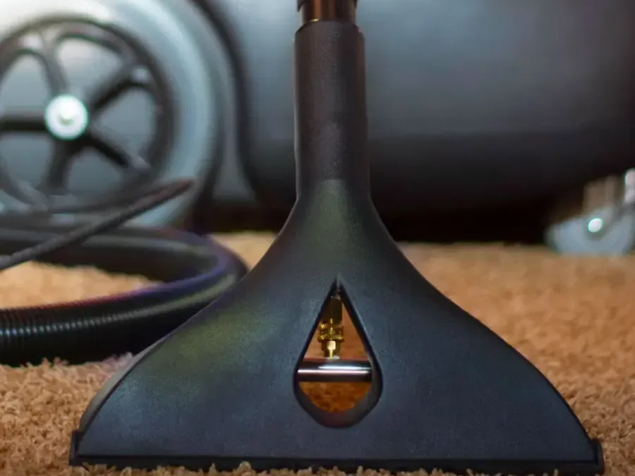 Extraction wand drawing water out of soaked carpet in a living room