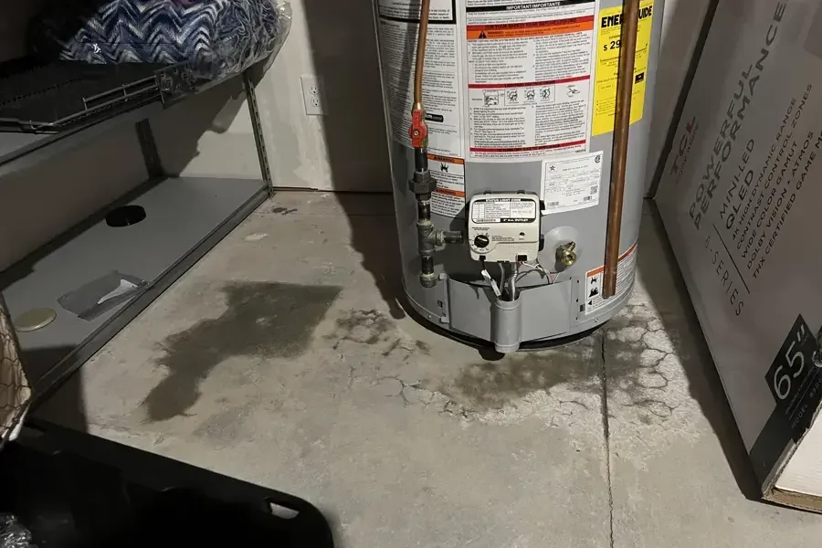 Water spreading across a garage floor from a leaking water heater tank
